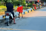 Hàng chục người tắm mát dưới con mương nằm sát đường lớn